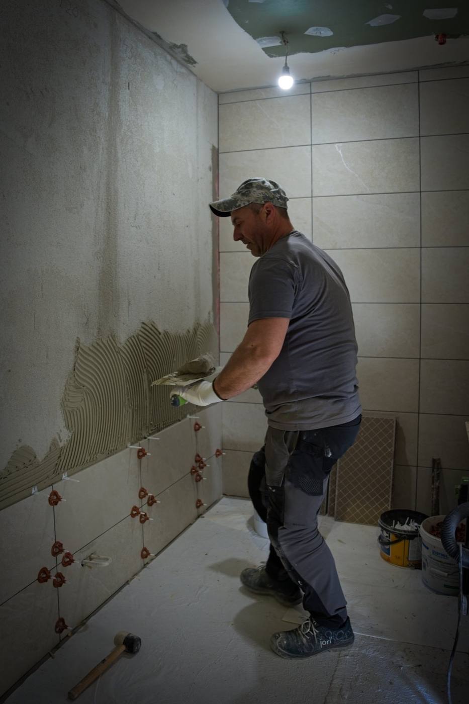 Fliesenleger von Boss Bau beim Verlegen von Wandfliesen
