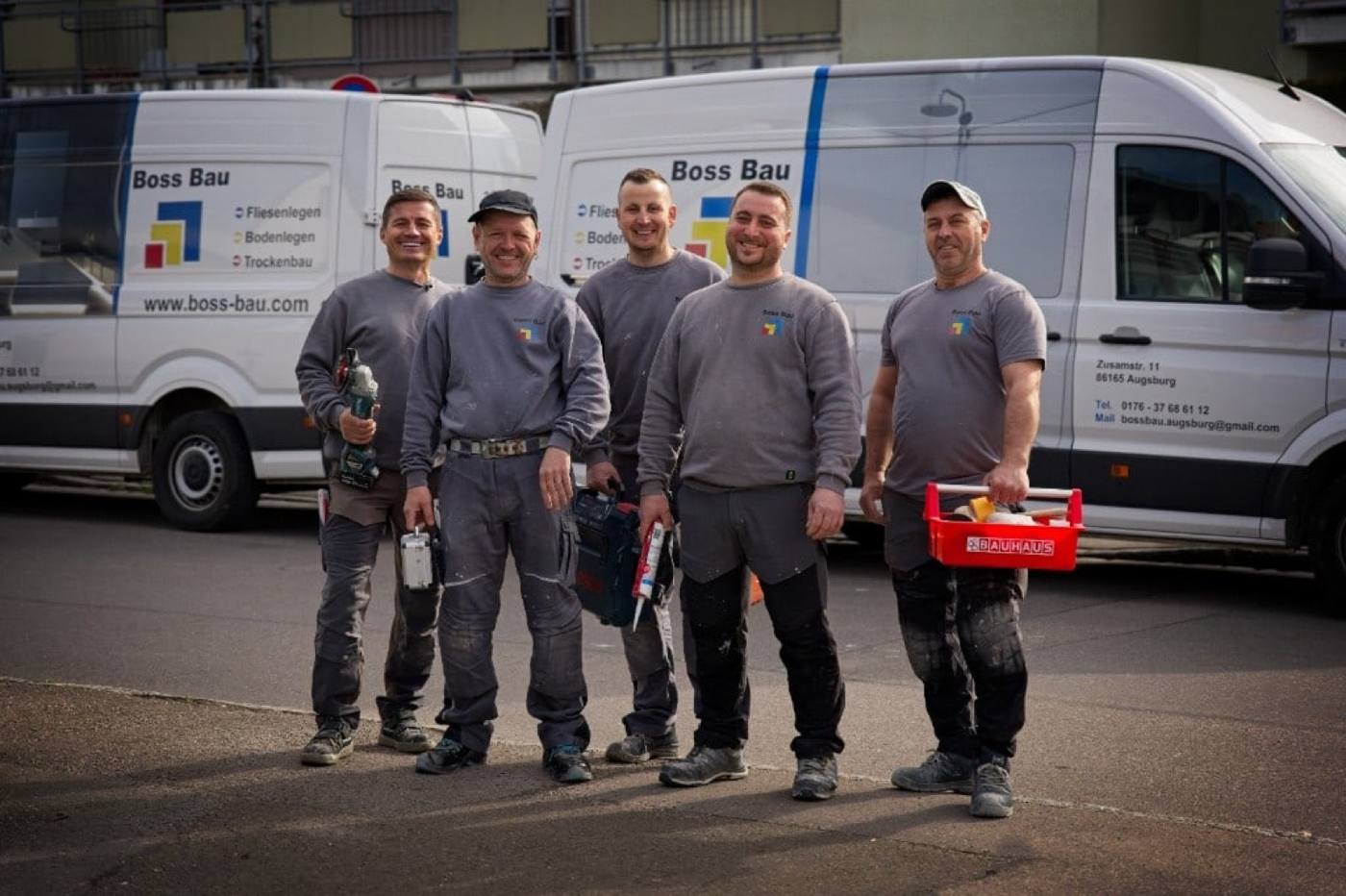 Das Team von Boss Bau vor den Firmenwagen